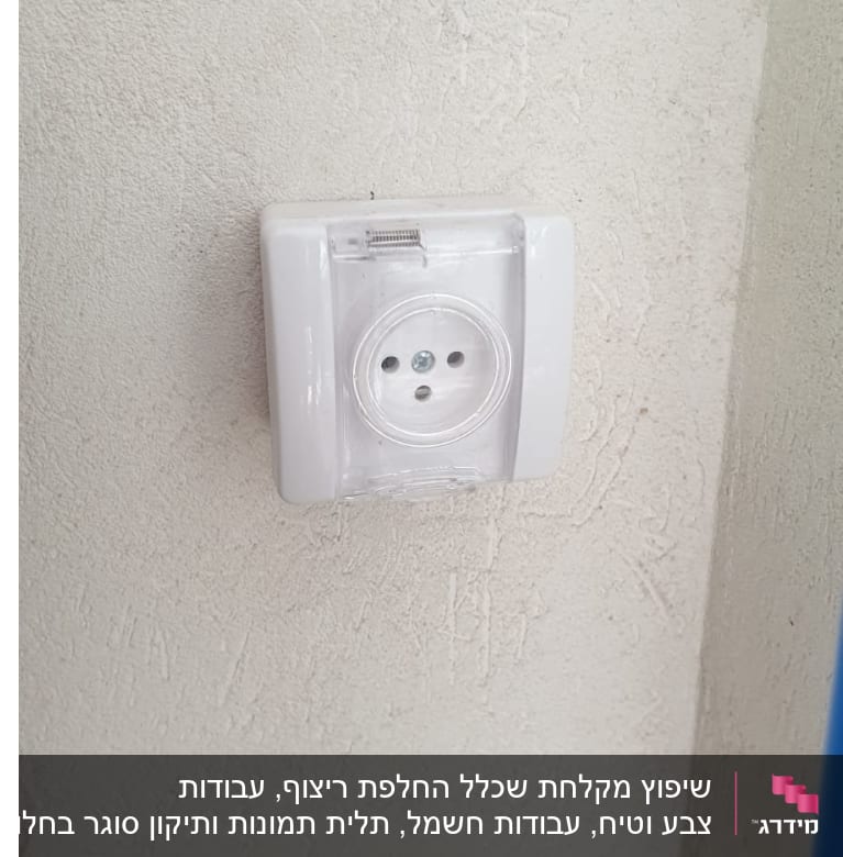 שקע חשמל עם כיסוי שקוף על קיר